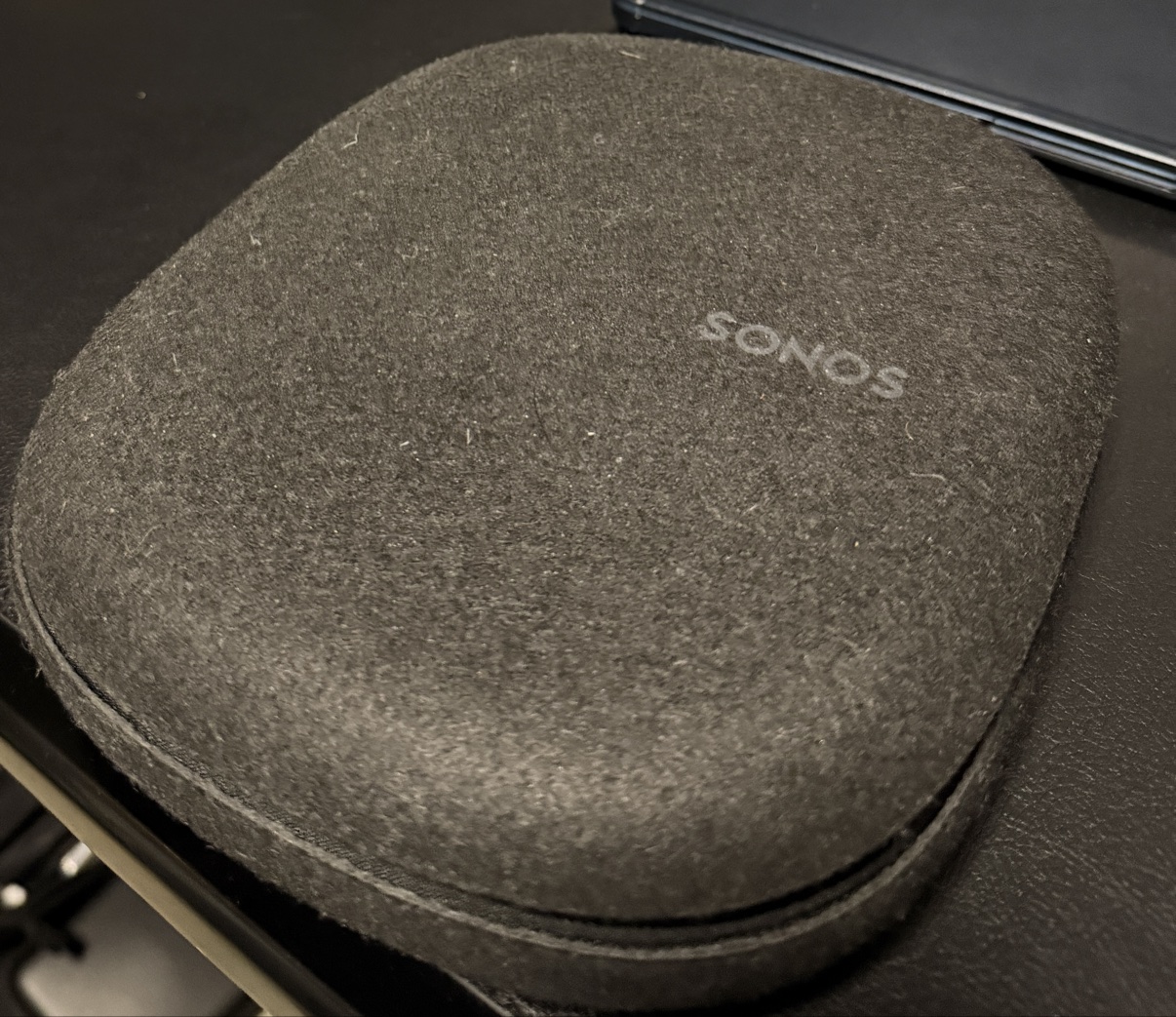 Closed gray felt Sonos Ace case with the SONOS logo